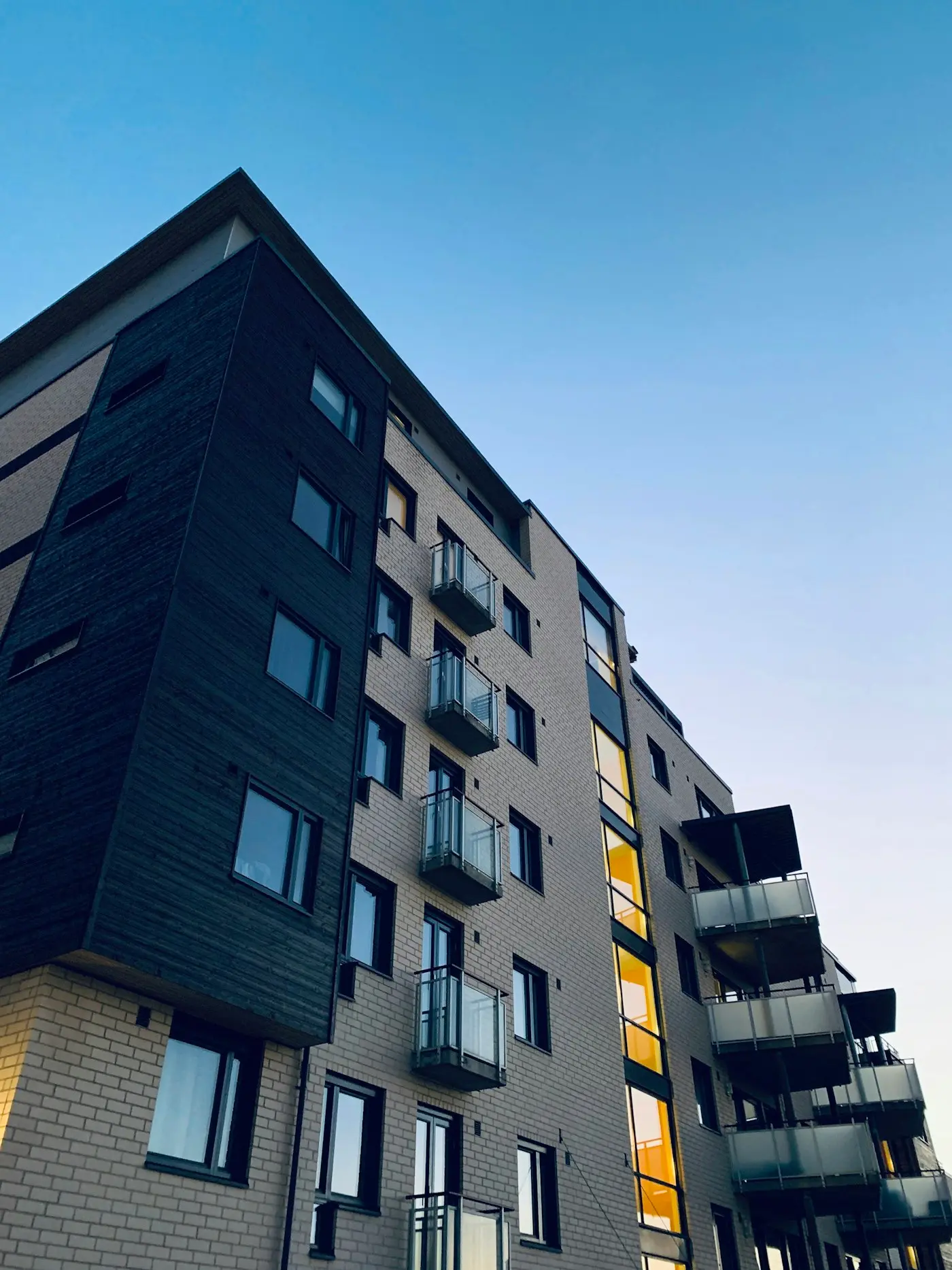 Apartment building facade at dusk with lit windows